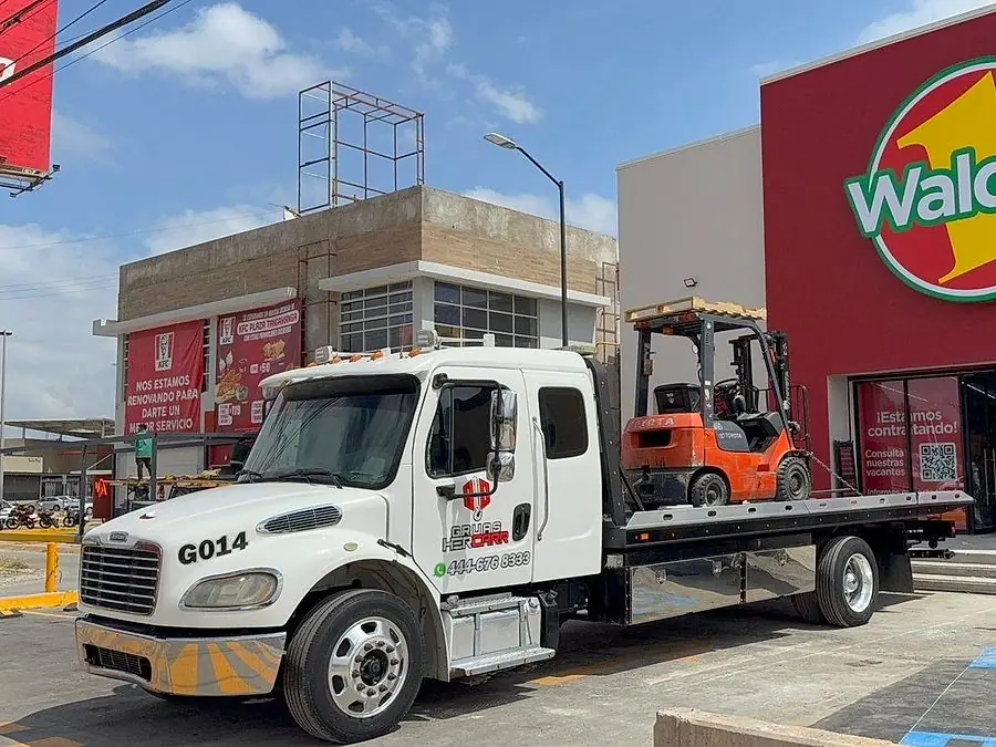 Plataforma HERCARR trasladando un montacargas industrial