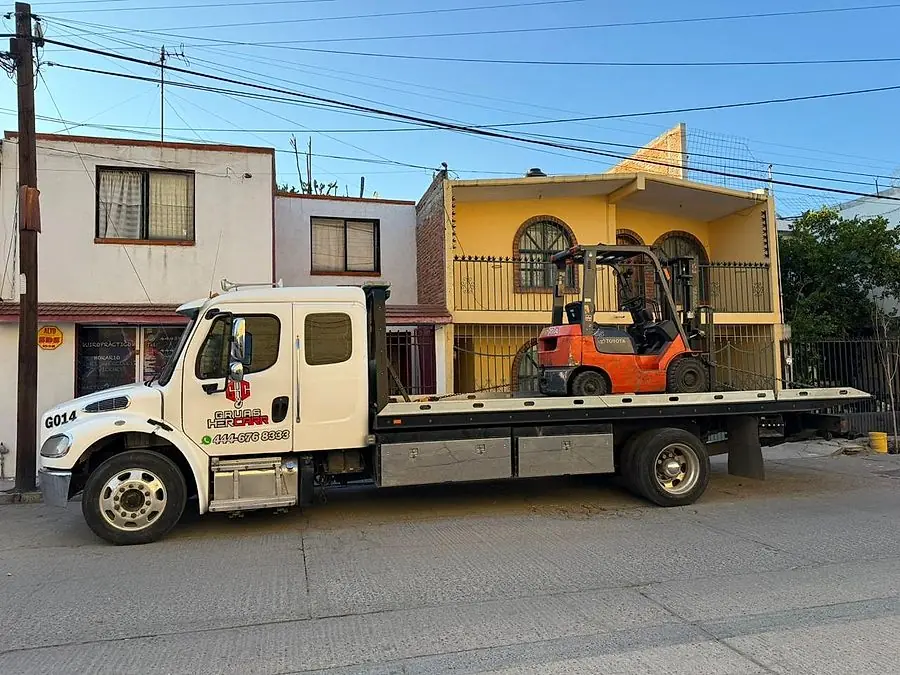 Grúa de plataforma HERCARR cargando un montacargas